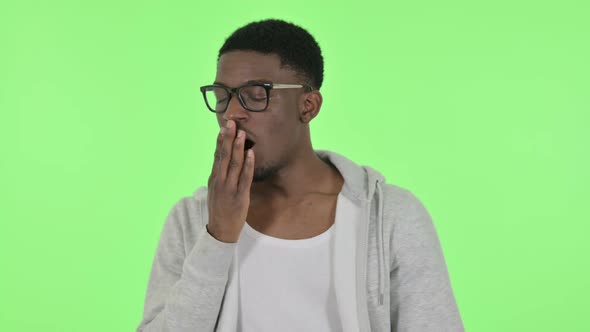 African Man Yawning on Green Background