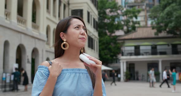 Woman feel so hot and use of hand carry fan at outdoor