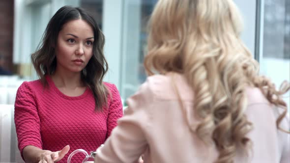 Two Young Women Argue in Cafe