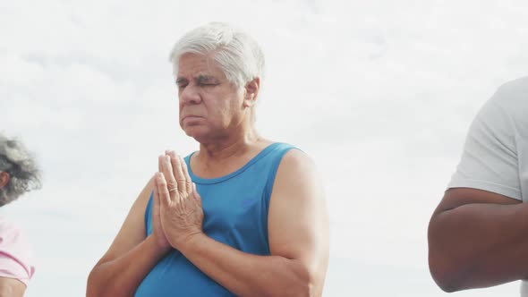 Happy senior diverse people practicing yoga in garden at retirement home