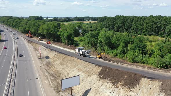 Roadworks of a new asphalt road. Modern machinery working on a road construction