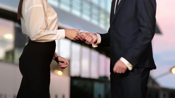 Businessman Pays Businesswoman in Euros and They Shake Hands After That.