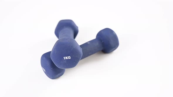 Two Blue Dumbbells are Spinning on a White Background