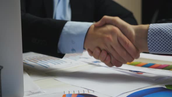 Male Hands of Two Businessmen Shaking Hands After Closing Good Deal at Office