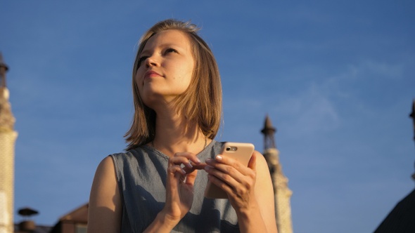 Pretty young woman texts on her mobile phone.