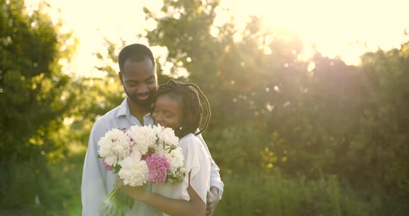 Black Romantic Couple with Peony Bunch in Rural Setting