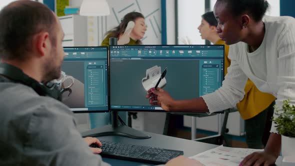 Black Employee Pointing on Monitor Explaining Project