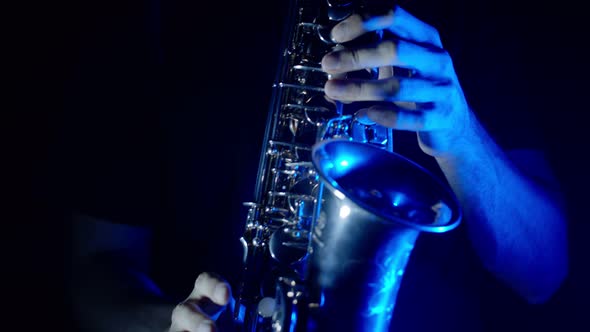 Live Performance of Saxophonist Man with Saxophone Dancing on Concert Stage with Blue Neon Lights