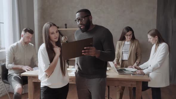 Business Communication of an Afro American and White Woman Dressed in Casual in the Office