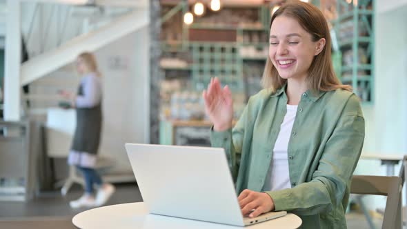 Professional Woman Doing Video Chat on Laptop in Cafe 