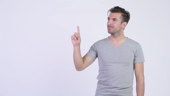 Young Happy Hispanic Man Thinking While Pointing Up