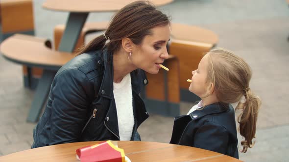 Mom and Daughter Are Sitting at the Table