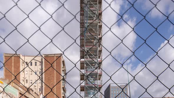 Construction Site with Clouds Behind Wire Fence