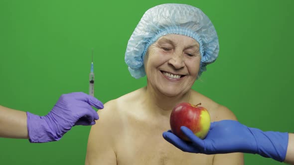 Elderly Female Lady in Protective Hat Chooses Treats Medications or Fruits