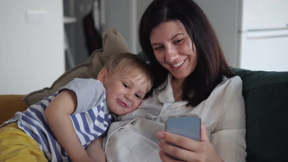 Mom And Child Communicate Together Via Video Link With Dad And Relatives