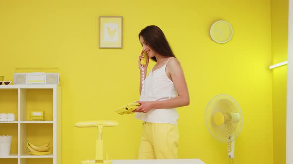 Business Woman Is Talking on Yellow Retro Telephone