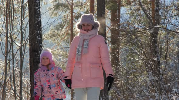 Child with Mom Walking in Sunny Frosty Winter Day