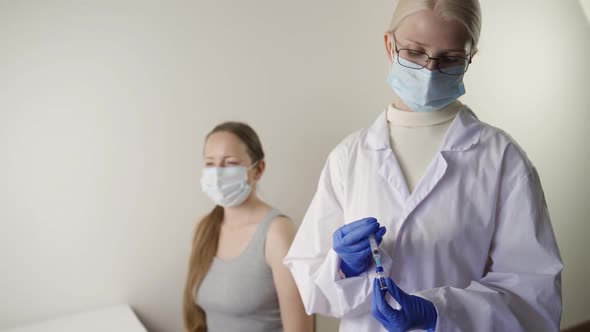 Doctor Doing Vaccine Injection to a Female Patient in a Health Clinic