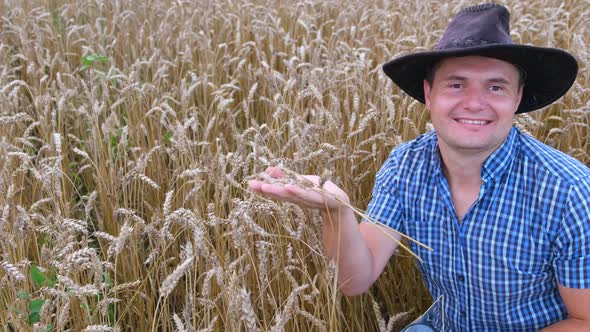 Young Agronomist on a Wheat Field Holding Spikelets