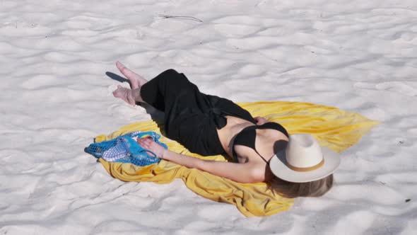 Woman lying on beach in bikini and relax