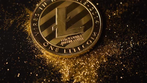 Litecoin Coin Falls on Black Surface Scattering Sparkles Macro