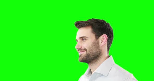 Smiling man standing against green screen