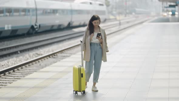 Portrait of Young Woman with Suitcase Standing on Platform