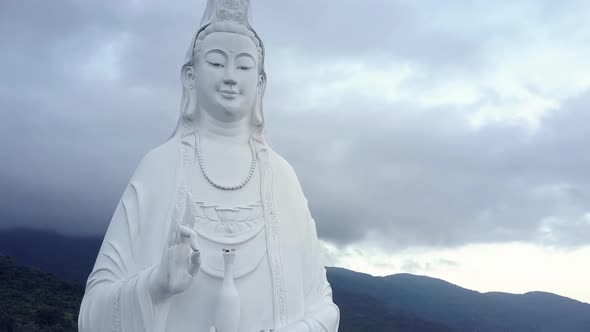 Aerial View White Buddha Statue with Necklace Against Hills