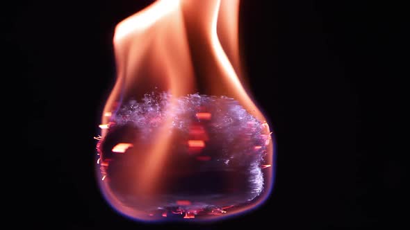 Fire burning on steel wool as it is spinning while floating. alt