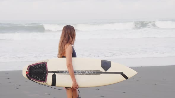 Surfer Walking Along Ocean Beach