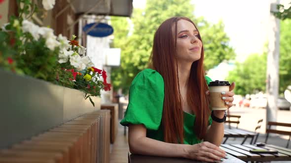 Tracking Shot of Happy Attractive Young Woman Enjoying Cup of Coffee Sitting at Table in Outdoor