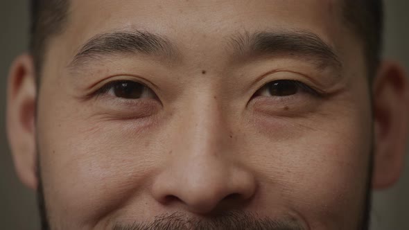 Extreme Closeup of a Korean Man's Smiling Eyes Opening in Slow Motion and Looking at Camera