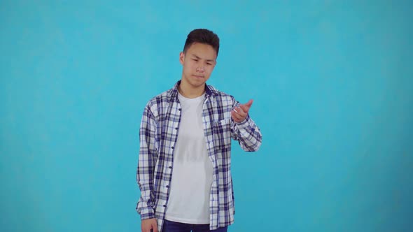 Young Asian Man Make a Facepalm Gestures on Blue Background
