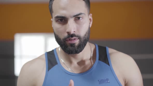 Close-up of Brown-eyed Middle Eastern Boxer Pointing at Camera and Back