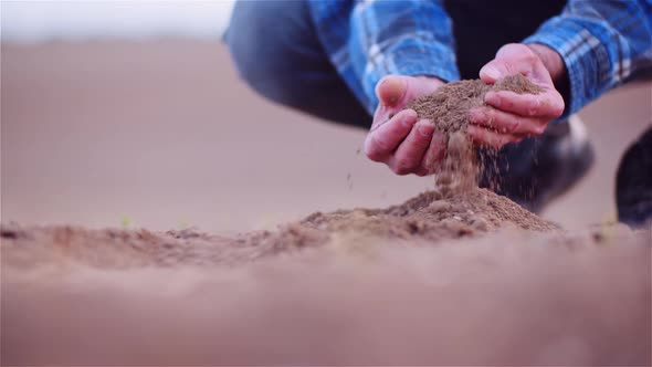 Farmer Examining Organic Soil in Hands, Farmer Touching Dirt in Agriculture Field