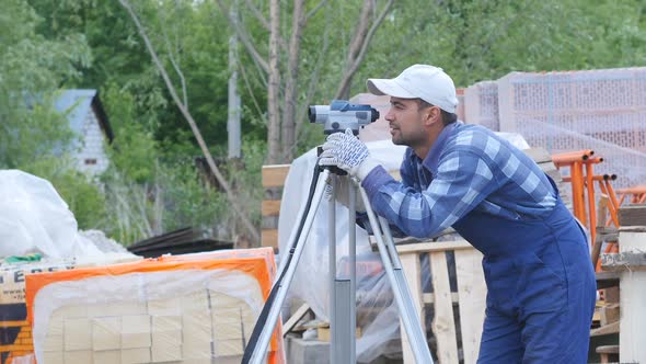 Builder Measures Flatness of Paving Bricks By Using Device