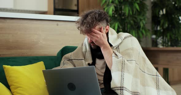 Sick Young Man Using Laptop Coughing at Home