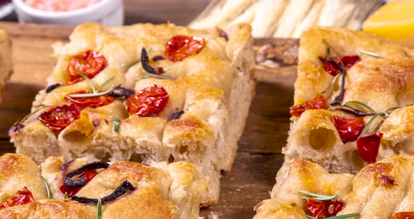 Homemade italian flat bread - Focaccia contorta. With olives, olive oil, rosemary, tomatoes. Traditi