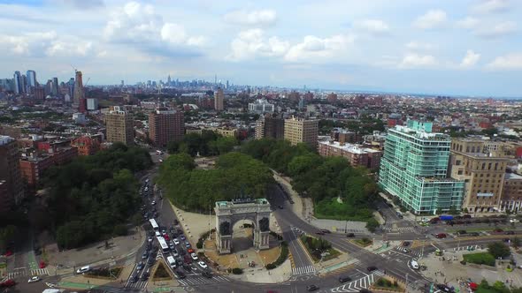 Panning aerial view of Grand Army Plaza circle in Brooklyn with NYC skyline in the distance 4K.