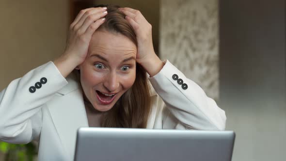 A Happy Excited Young Female Office Worker Raises Her Hands and Screams with Joy Celebrating a