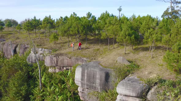 Aerial view of Asian tourists hiker man hiking or trekking on trail on mountain hill cliff