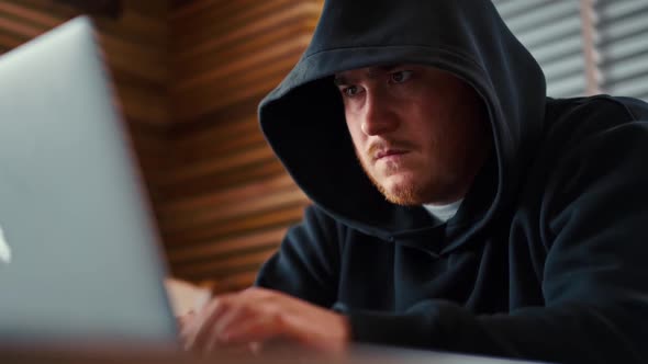 Male involved hacking into security systems. Freelancer using laptop working from home.