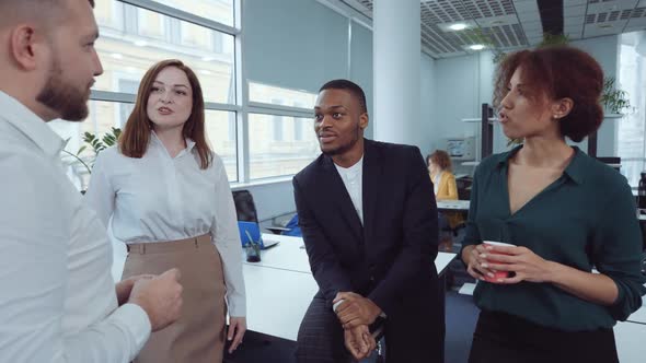 Multiethnic colleagues at coffee break in office