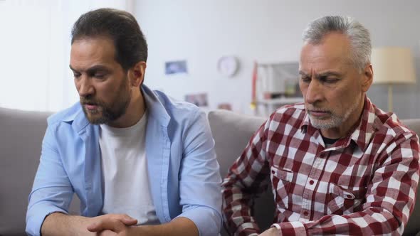 Elderly Male Comforting Anxious Middle Aged Son Suffering Divorce, Experience