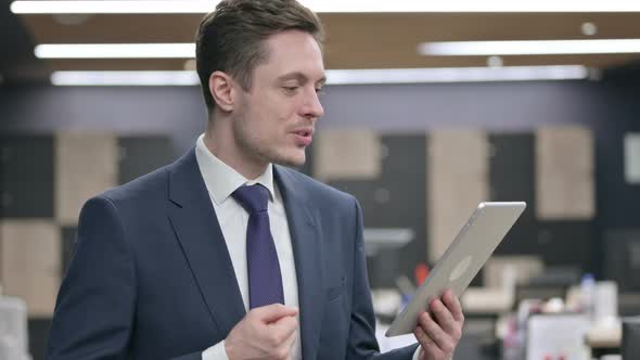 Businessman Making Video Call on Tablet in Office