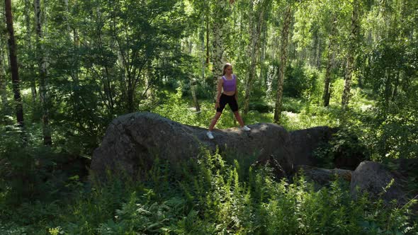 The Girl is Doing Fitness in the Forest