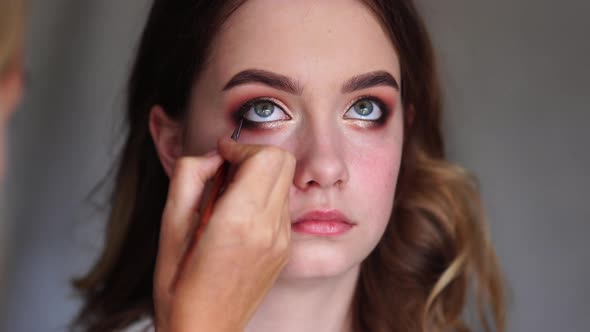 Girl Makeup Artist Paints the Eyes of a Young Girl