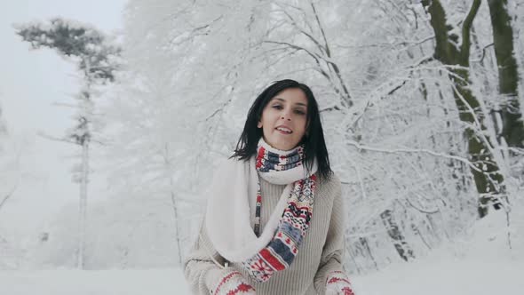 Woman Who Looks Into the Camera on a Frosty Winter Day and Who Walks in a Snow-Covered Forest