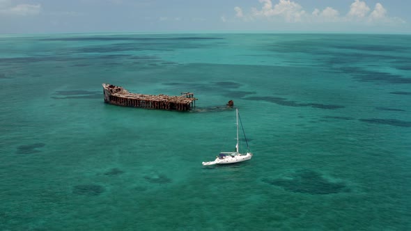 Motorboat Sailing Near The Wrecked SS Sapona Cargo Steamer At Port Royal In Bahamas. aerial