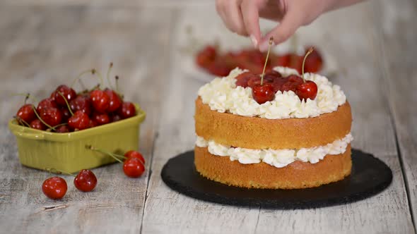 Young Female Confectioner Decorating Naked Cherry Cake.